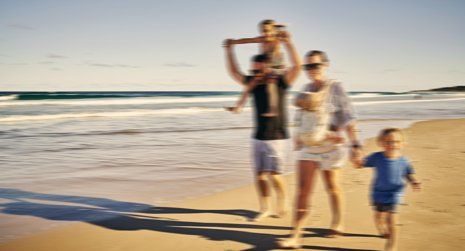 Nystagmus: Image of a happy family walking on the beach where vision is blurred as if the scene is moving quickly.